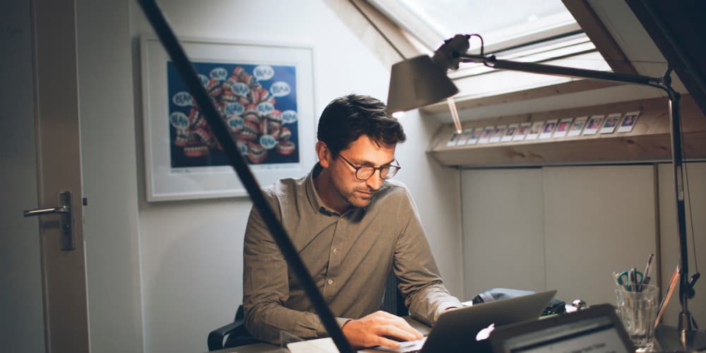 Man working in an attic office on his laptop