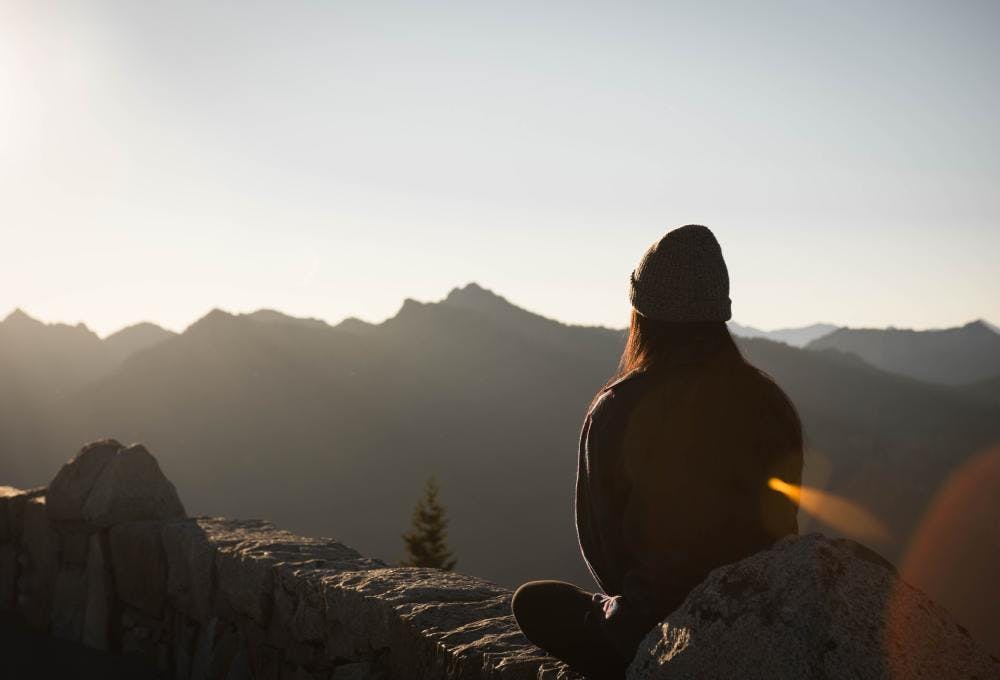 Women meditating in front of mountains