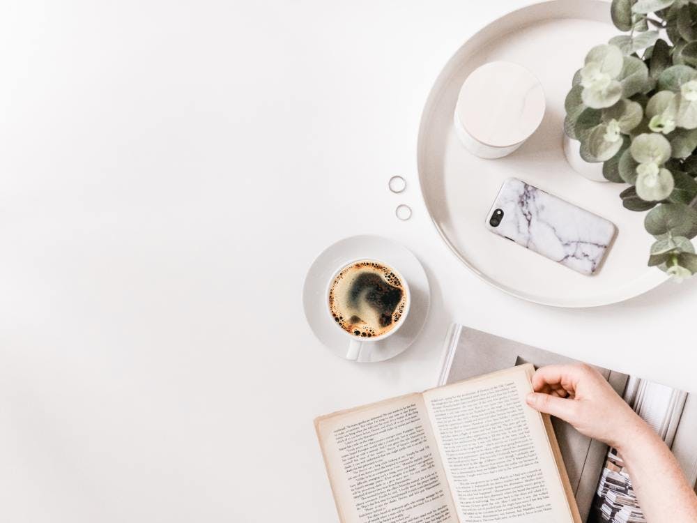 Someone reading their book with a coffee